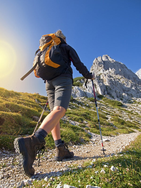 Young woman on a sunny day hiking in high mountains