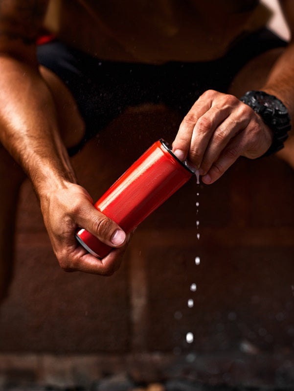 Athletic young man opening can of energy drink