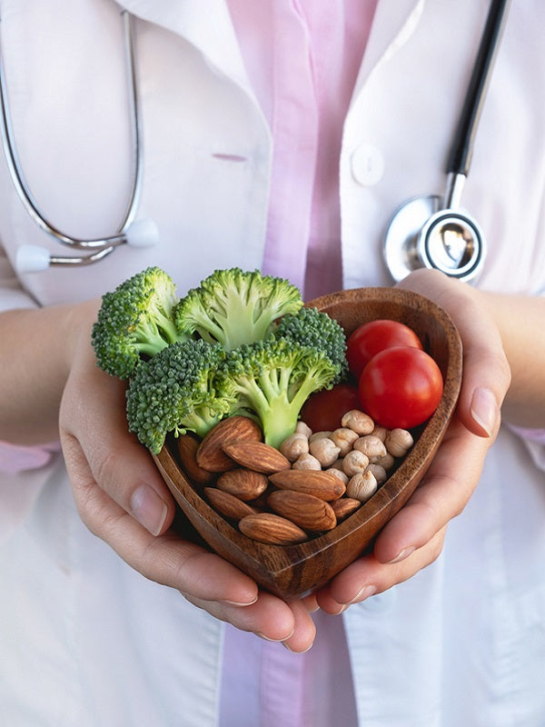 Doctor holding bowl with vegetables, almond nuts, and chickpea - healthy food for the heart.