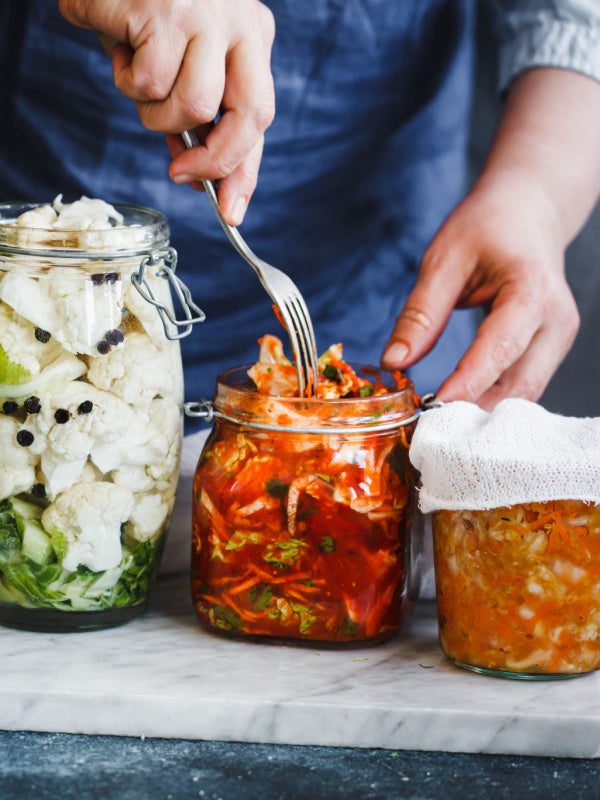 Person making fermented food in jars for probiotics